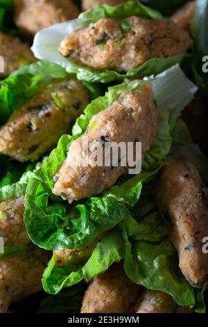 Palle di lenticchie cotte in stile turco. Cibo vegano turco Mercimek Koftesi (lenticchie). Piatti tradizionali locali con lenticchie e bulgaro. Foto Stock