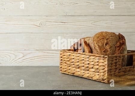 Cestino con pane fresco su tavola grigia Foto Stock