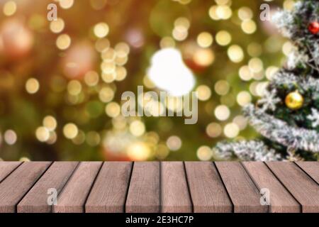 Sfondo delle vacanze di Natale. Tavolo di legno vuoto sopra la luce del bokeh per il montaggio del prodotto Foto Stock
