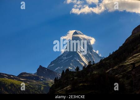 L'iconica montagna del Cervino vista da Zermatt, Vallese (Wallis), Svizzera con nuvole bianche intorno alla cima in serata Foto Stock