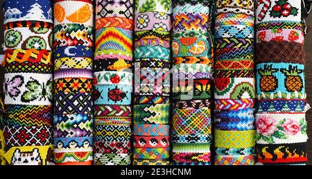 Molti bracciali di amicizia intrecciati a mano fatti di filo di ricamo. Modelli alfa e normali Foto Stock