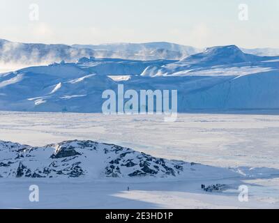 I pescatori e le loro barche ormeggiate in un porto di ghiaccio. Inverno al Icefjord Ilulissat, situato nella baia di Disko nella Groenlandia occidentale, l'Icefjord fa parte Foto Stock