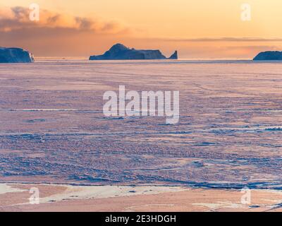 Tramonto durante l'inverno all'Ilulissat Icefjord, situato nella baia di Disko nella Groenlandia occidentale, l'Icefjord fa parte del patrimonio mondiale dell'UNESCO. America Foto Stock