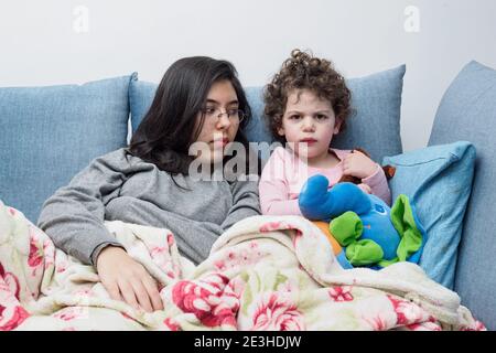 Interazione di due sorelle su un divano nel soggiorno Foto Stock