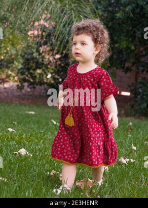 La ragazza del toddler gioca all'aperto nel suo giardino Foto Stock