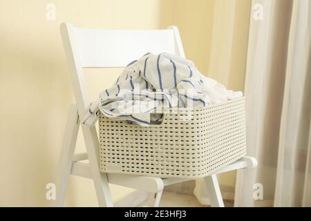 Cestino con vestiti sminuzzati su sedia di legno Foto Stock