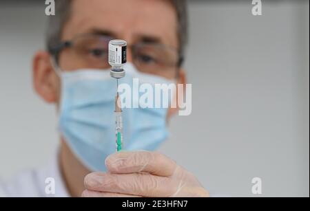 Pulsnitz, Germania. 19 gennaio 2021. Marcus Pohl, direttore medico della VAMED Clinic Schloss Pulsnitz, prepara il vaccino da Biontech/Pfizer per la vaccinazione di un'infermiera contro il nuovo coronavirus. In considerazione dell'elevato numero di pazienti gravemente malati del Covid 19, gli ospedali della Sassonia sono ora sostenuti nelle loro cure da cliniche di riabilitazione. Nella fase attuale della pandemia, il Ministero della Sanità ha riconosciuto lo status di ospedale ausiliario alle strutture idonee e ha assunto pazienti. Credit: Robert Michael/dpa-Zentralbild/ZB/dpa/Alamy Live News Foto Stock