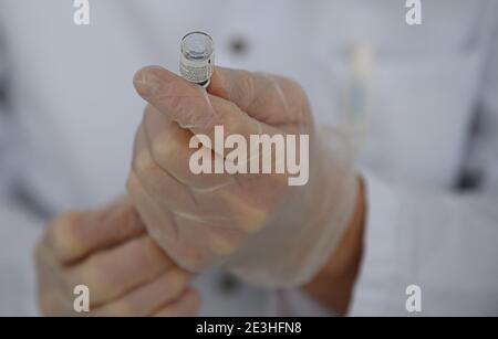 Pulsnitz, Germania. 19 gennaio 2021. Marcus Pohl, direttore medico della VAMED Clinic Schloss Pulsnitz, prepara il vaccino da Biontech/Pfizer per la vaccinazione di un'infermiera contro il nuovo coronavirus. In considerazione dell'elevato numero di pazienti gravemente malati del Covid 19, gli ospedali della Sassonia sono ora sostenuti nelle loro cure da cliniche di riabilitazione. Nella fase attuale della pandemia, il Ministero della Sanità ha riconosciuto lo status di ospedale ausiliario alle strutture idonee e ha assunto pazienti. Credit: Robert Michael/dpa-Zentralbild/ZB/dpa/Alamy Live News Foto Stock