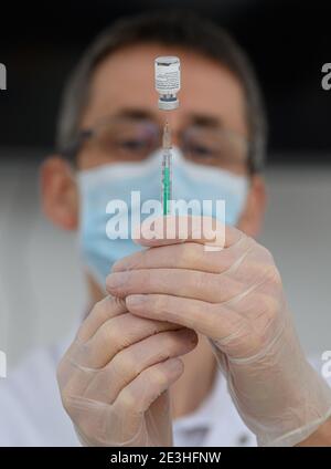 Pulsnitz, Germania. 19 gennaio 2021. Marcus Pohl, direttore medico della VAMED Clinic Schloss Pulsnitz, prepara il vaccino da Biontech/Pfizer per la vaccinazione di un'infermiera contro il nuovo coronavirus. In considerazione dell'elevato numero di pazienti gravemente malati del Covid 19, gli ospedali della Sassonia sono ora sostenuti nelle loro cure da cliniche di riabilitazione. Nella fase attuale della pandemia, il Ministero della Sanità ha riconosciuto lo status di ospedale ausiliario alle strutture idonee e ha assunto pazienti. Credit: Robert Michael/dpa-Zentralbild/ZB/dpa/Alamy Live News Foto Stock