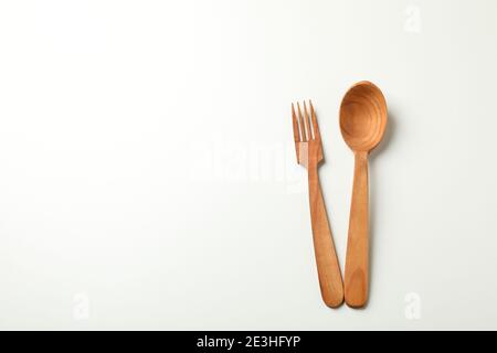 Cucchiaio e coltello in legno su sfondo bianco, spazio per il testo Foto Stock