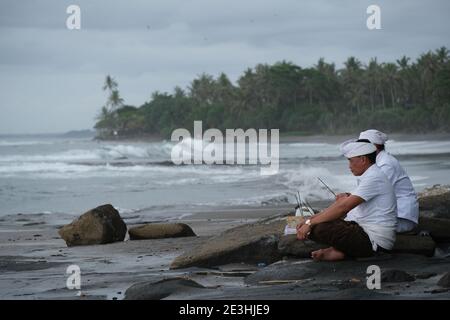 Indonesia Bali Pekutatan - Servizio di preghiera nel vecchio tempio indù Pantai Medewi Foto Stock