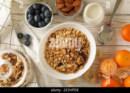 Concetto di gustosa colazione con granola su sfondo di legno Foto Stock