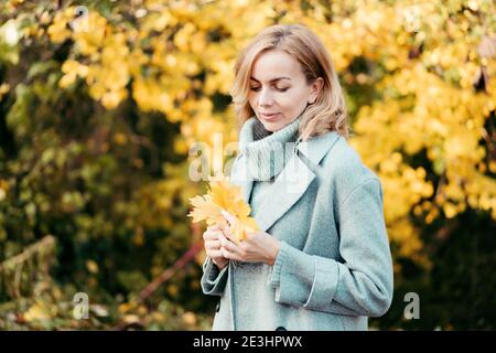 donna che tiene un bouquet di foglie Foto Stock