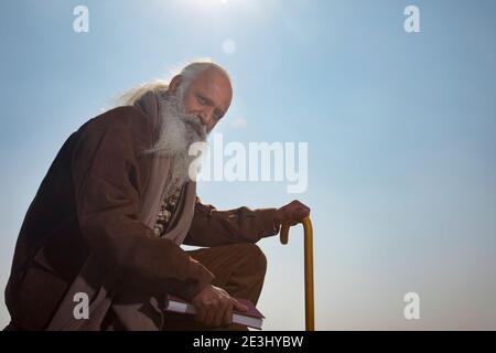 Uomo anziano barbuto in occhiali da sole rave al neon incandescente  guardando lontano su sfondo rosa Foto stock - Alamy