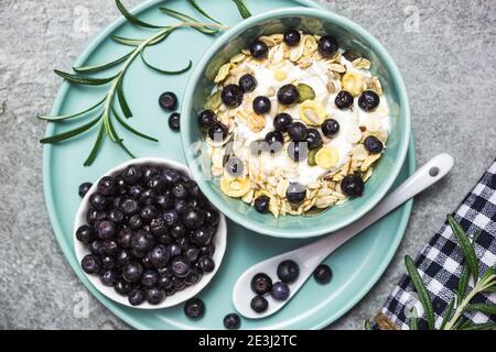 Granola di yogurt greco con mirtilli freschi su un tavolo di pietra, vista dall'alto con spazio per il testo. Cibo sano, snack o colazione. Foto Stock