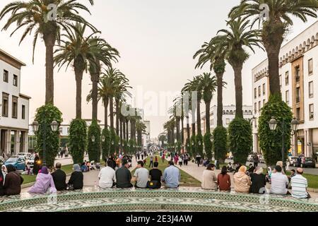 La gente del posto si raduna per chiacchierare e socializzare in un piccolo parco in Avenue Mohammed V nel quartiere Ville Nouvelle di Rabat, Marocco. RABAT prima sera nel Foto Stock
