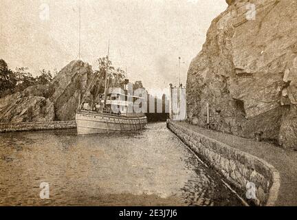 Una fotografia stampata del 1940 di una nave che lascia Trollhattan Lock nel canale di Gota ( Göta kanal) che collega il Baltico con il Katteg. Il canale di Göta fa parte di un corso d'acqua lungo 390 km (240 mi), Collegamento di numerosi laghi e fiumi che collegano Goteborg (Göteborg) a Söderköping sul Mar Baltico attraverso il fiume Trollhätte kanal e Göta älv e attraverso i grandi laghi di Vänern e Vättern. E' stato costruito all'inizio del diciannovesimo secolo come un canale d'acqua commerciale, ma è ora utilizzato principalmente come attrazione turistica e ricreativa Foto Stock