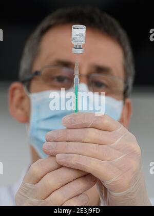 Pulsnitz, Germania. 19 gennaio 2021. Marcus Pohl, direttore medico della VAMED Clinic Schloss Pulsnitz, prepara il vaccino da Biontech/Pfizer per la vaccinazione di un'infermiera contro Corona. In considerazione dell'elevato numero di pazienti gravemente malati del Covid 19, gli ospedali della Sassonia sono ora sostenuti nelle loro cure da cliniche di riabilitazione. Nella fase attuale della pandemia, le strutture idonee sono state riconosciute come ospedale ausiliario dal Ministero della Salute e hanno assunto il riconoscimento dei pazienti: Robert Michael/dpa-Zentralbild/dpa/Alamy Live News Foto Stock