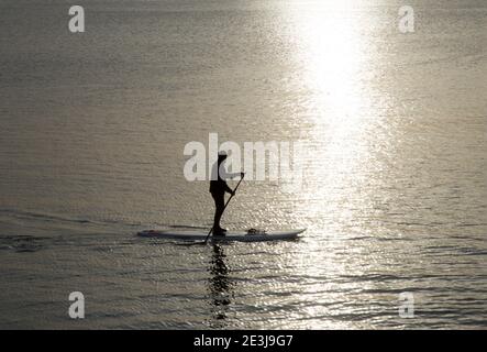 Lone Paddle Boarder godendo la calma di una mattinata di inverni a Torbay. Foto Stock