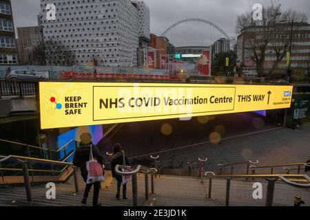 Londra, Regno Unito. 19 gennaio 2021. Cartello alla stazione di Wembley Park che dirige il pubblico al Centro vaccinazioni. Centro di vaccinazione NHS a Wembley. Il Centro NHS Vaccination, nel Centro Olimpico dell'Ufficio, all'ombra dello Stadio di Wembley su Fulton Road, ha accolto i suoi primi pazienti lunedì mattina, 18 gennaio. Si tratta di uno dei 25 nuovi siti aperti a Londra questa settimana, portando il totale dei siti di vaccinazione in tutta la capitale a 170. Decine di altri saranno aperti nelle prossime settimane Credit: Mark Thomas/Alamy Live News Foto Stock