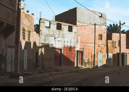 Città fantasma nel deserto del Sahara con decadente casa abbandonata e strada di sabbia sterrata, Marocco Foto Stock