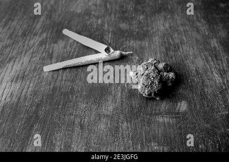 Gemme di marijuana, e giunti rotolati di cannabis su sfondo astratto di legno.medico e medicina, ricreativo, negozio di erbe infestanti, concetto di shopping. Foto Stock