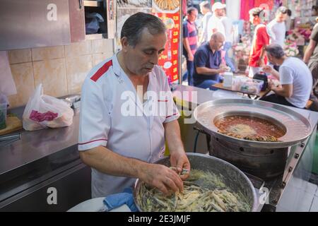 Istanbul, Turchia - Settembre 19 2017: Un venditore di strada turco prepara fresche sardine tradizionali al di fuori del Grand Bazaar di Istanbul. Foto Stock