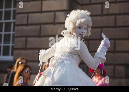 Edimburgo, Scozia - Agosto 16 2016: Un suonatore di pantomime in costume lungo lo storico Royal Mile di Edimburgo, Scozia, all'annuale Fringe Foto Stock