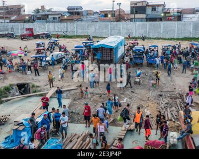 Iquitos, Perù - Dic, 2019: Una folla di persone locali su una nave da carico e una costa fangosa di un porto sul fiume Amazzone a Iguitos. Amazzonia. Sout Foto Stock