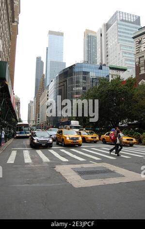 New York taxi taxi giallo taxi auto fermata pedonale attraversando strada grattacieli città grattacielo città alta grande grande autobus attesa fermata Foto Stock