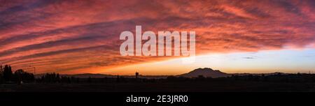 Viste panoramiche di un colorato tramonto nell'area della Baia di San Francisco Est, con nuvole dai colori luminosi che coprono il cielo, e il Monte Diablo visibile sull'orizzontale Foto Stock