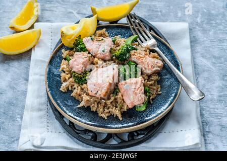 Pilaf di salmone e broccoli guarnito con spicchi di limone Foto Stock