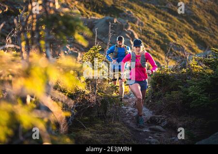 L'uomo e la donna corrono all'alba in montagna Foto Stock