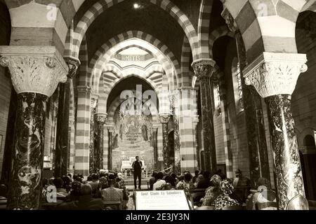 PARAY-LE-MONIAL, FRANCIA - 25 AGOSTO 2018: Pellegrini africani nella Cappella di San Claude de la Colombiere. Seppia foto storica Foto Stock