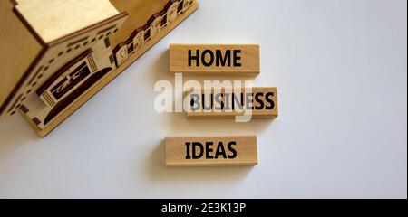 Simbolo delle idee di affari domestici. Blocchi di legno formano le parole 'idee di affari domestici 'vicino casa in miniatura su sfondo bianco bello. Affari, busi domestico Foto Stock