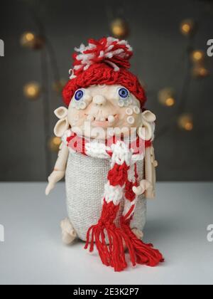 Giocattolo fatto a mano, spirito di Natale in argilla polimerica, cappello rosso bianco lavorato a maglia e sciarpa Foto Stock
