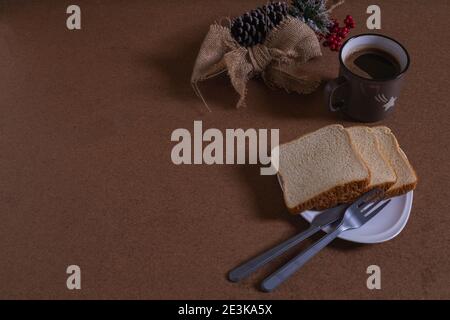 bere il caffè con il pane, creando nuove idee alla mia scrivania Foto Stock