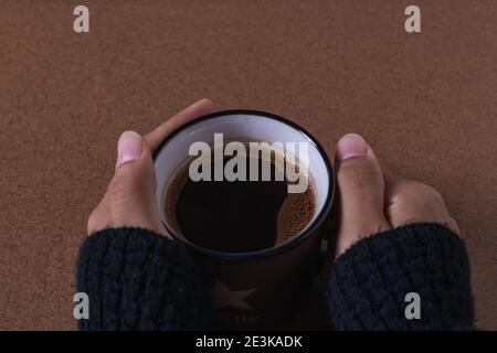 bere il caffè con il pane, creando nuove idee alla mia scrivania Foto Stock