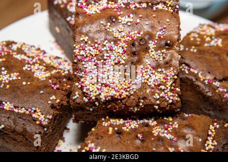 Un delizioso mucchio di fette di torta brownie al cioccolato ricoperte di spruzzare Foto Stock