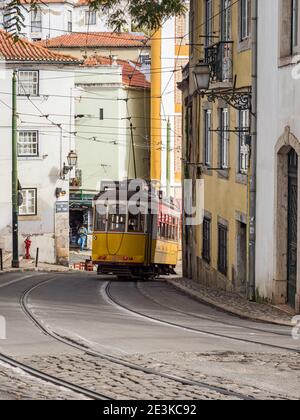 Tram giallo classico ad Alfama, il quartiere più antico di Lisbona, Portogallo, Europa. Foto Stock