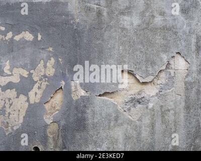 Muro di cemento con pezzo di intonaco che è caduto e piccoli punti di peeling Foto Stock
