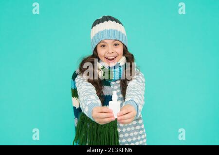 allegro capretto ragazza libero naso chiuso con gocce nasali in maglieria su sfondo blu, coronavirus. Foto Stock