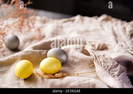 Uova di Pasqua naturali tinte gialle e grigie. Arredamento elegante casa vacanza. Foto Stock