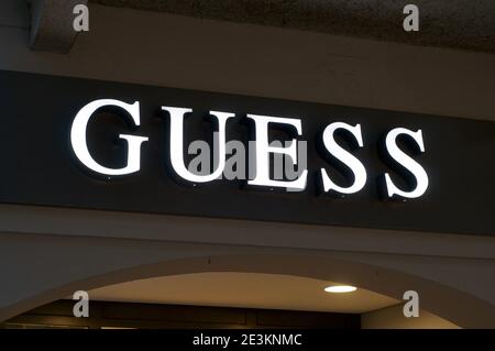 Lugano, Ticino, Svizzera - 14 gennaio 2021 : insegna luminosa del negozio di congettura appesa all'ingresso del negozio di Lugano. Guess è un crusca di abbigliamento americano Foto Stock