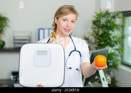 nutrizionista femminile che tiene una mela verde e un equilibrio Foto Stock