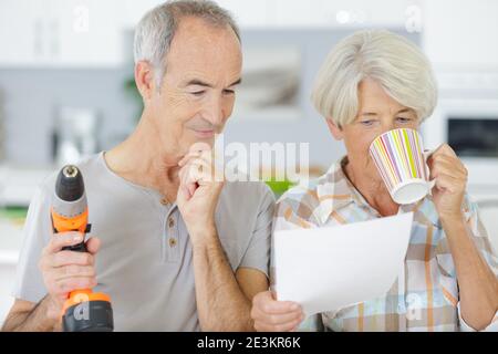 coppia anziana che guarda al piano di una nuova cucina Foto Stock