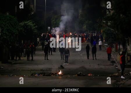 Tunisi, Tunisia. 19 gennaio 2021. I manifestanti affrontano la guardia nazionale tunisina (non raffigurata) durante gli scontri nel sobborgo di Ettadhamen, nella periferia nord-occidentale della capitale tunisina, in mezzo a un'ondata di proteste notturne con lo scoppio del 16 gennaio. Credit: Khaled Nasraoui/dpa/Alamy Live News Foto Stock