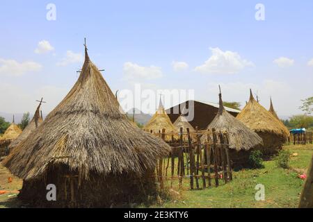 Piccole capanne in legno con tetti in paglia e croci ramoscelli sono le residenze dei sacerdoti in formazione, raggruppate sotto un cielo blu chiaro, vicino a Bahir Dar, E. Foto Stock