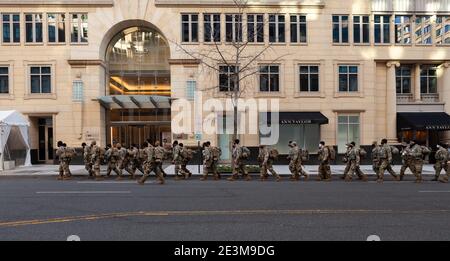 Washington, DC, USA, 19 gennaio 2021. Nella foto: Le truppe della Guardia Nazionale marciano in formazione di fronte a un edificio di uffici in centro. Sono alcune delle 25,000 truppe che si sono schierate a Washington per fornire sicurezza per l'insediamento di Joe Biden. I preparativi e le misure di sicurezza sono stati istituiti molto prima del solito a causa della minaccia di violenza posta dai sostenitori di Trump, dai supremacisti bianchi e da altri estremisti di destra. Credit: Alison C Bailey/Alamy Live News Foto Stock