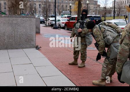 I membri del 116th Cavallry Brigade Combat Team, con sede a Gowen Field, Boise, Idaho, cercano di inasprire uno scoiattolo mentre si trovano in guardia vicino al Campidoglio degli Stati Uniti alla vigilia dell'inaugurazione del presidente eletto Joe Biden. Foto Stock